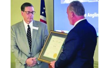 Photo submitted. John Loyack, Vice President of Economic Development for North Carolina Community Colleges presents Bill Slagle (left) with the Order of the Long Leaf Pine Award.